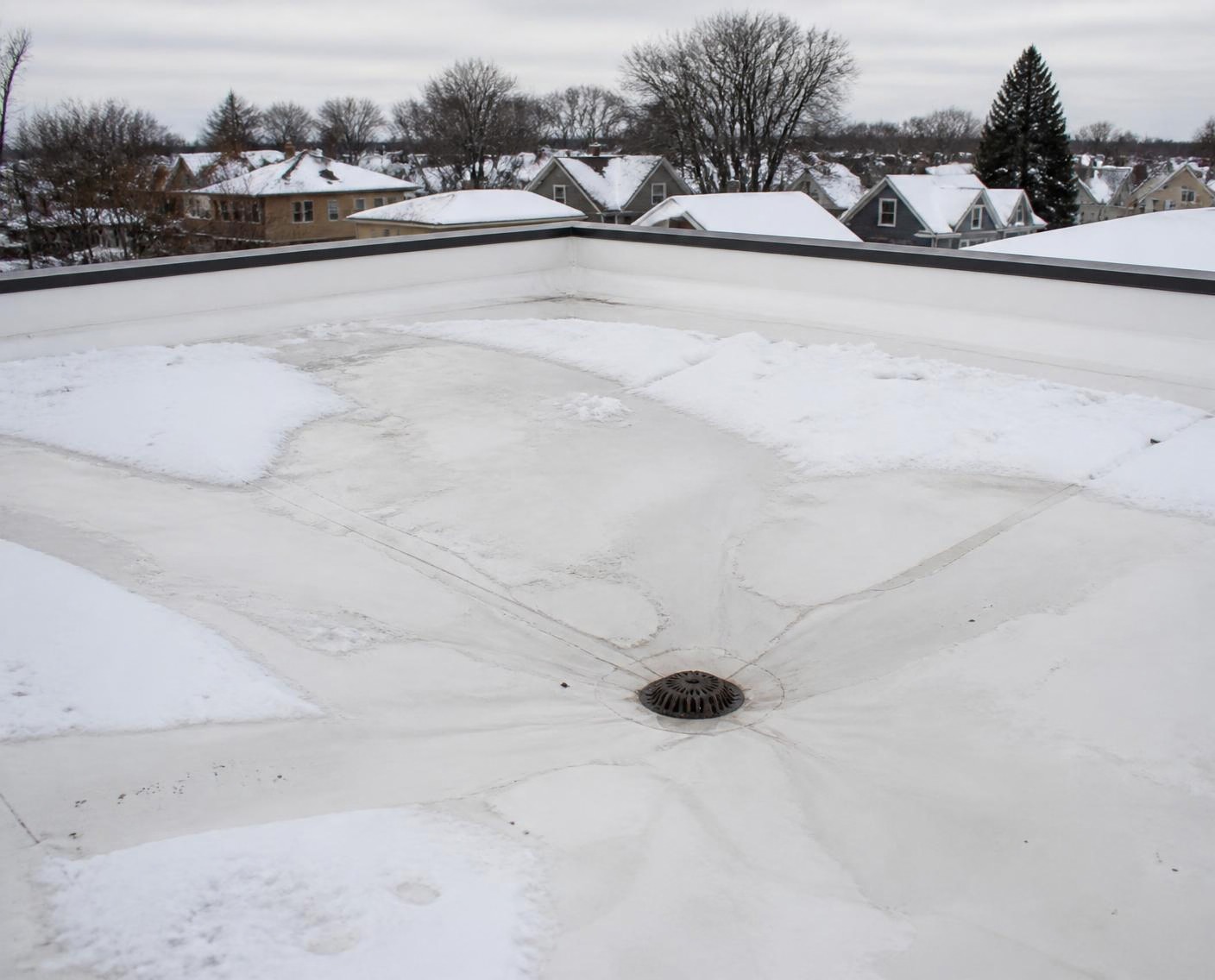 Snowmelt draining cleanly off a coated flat roof